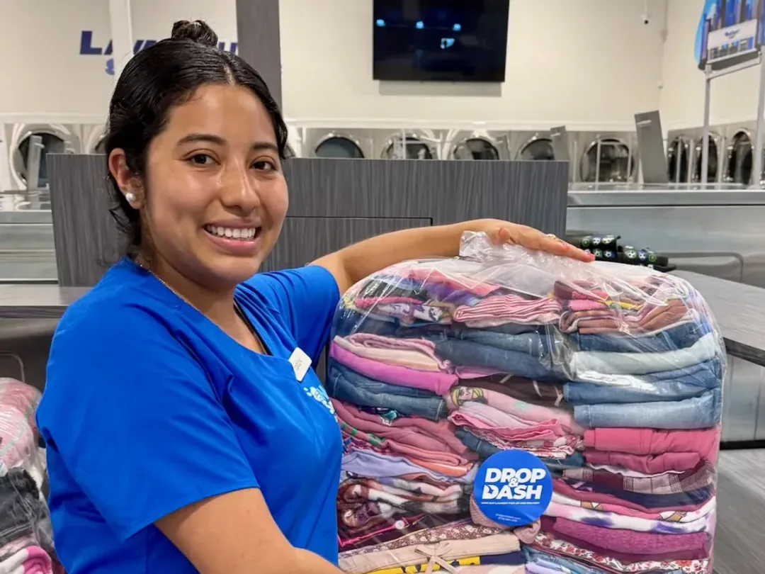 Drop & Dash team member with a finished laundry order inside the facility