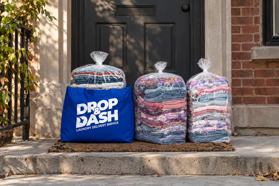 Blue Drop & Dash bag and plastic-wrapped clean laundry delivered to a front door