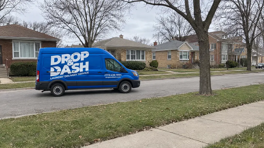 Drop & Dash delivery van driving down a tree-lined suburban street near Chicago