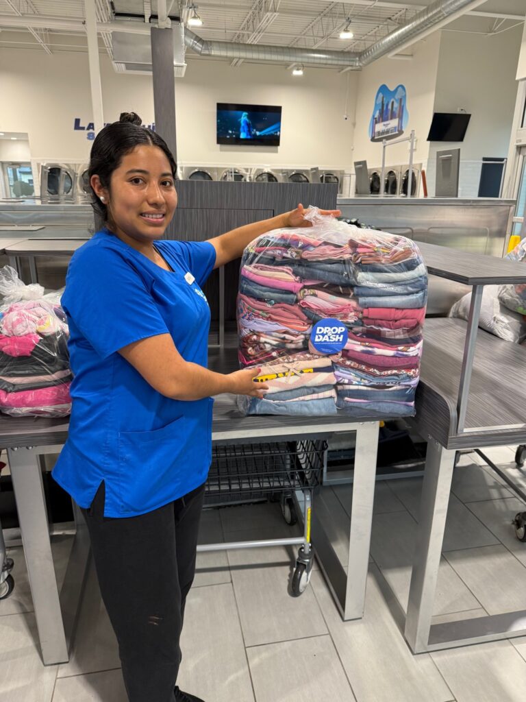Drop & Dash laundry attendant holding a wrapped, folded order